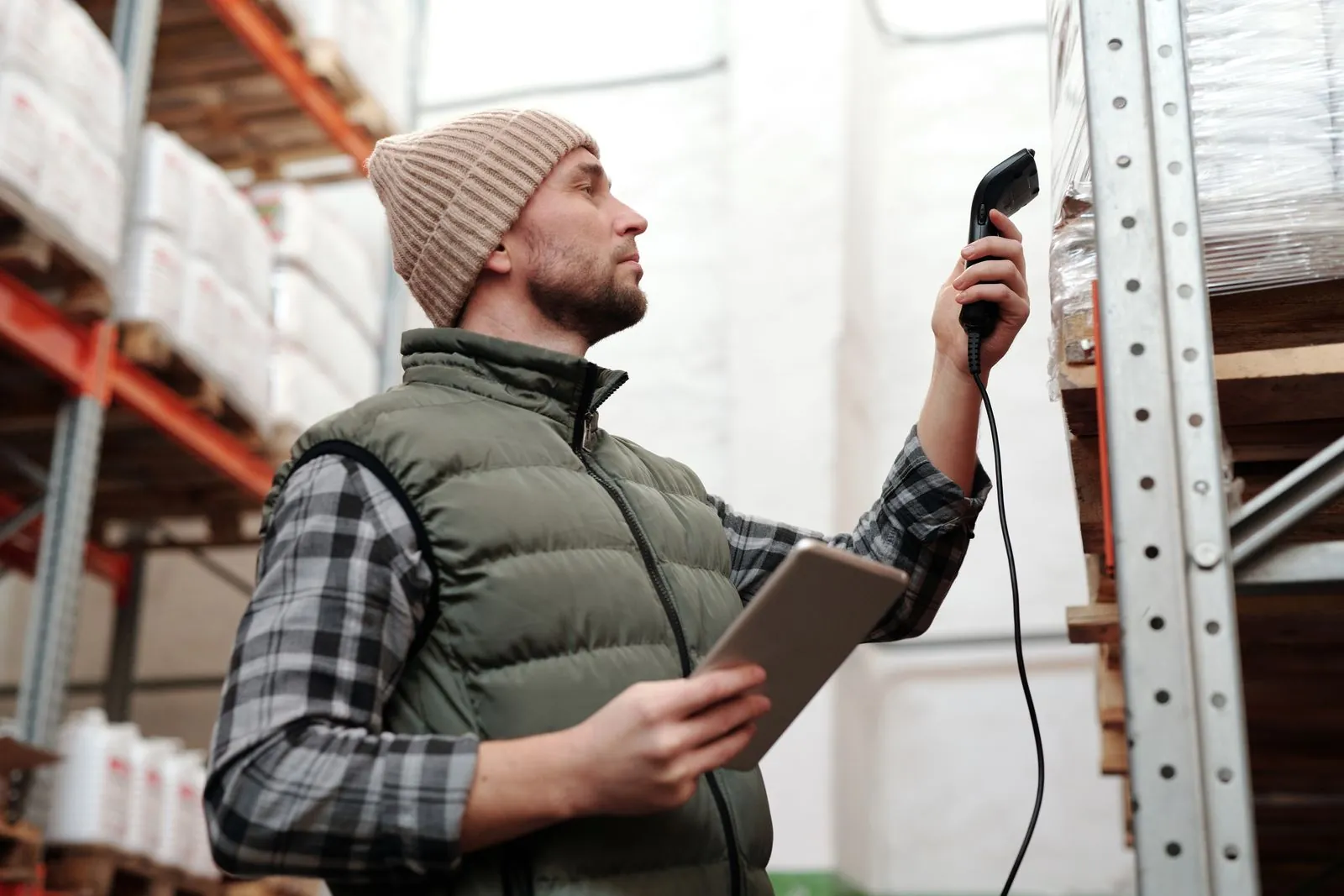 Procurement professional reviewing organized inventory in an industrial warehouse.